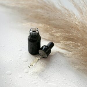 a bottle of black ink with a feather on it